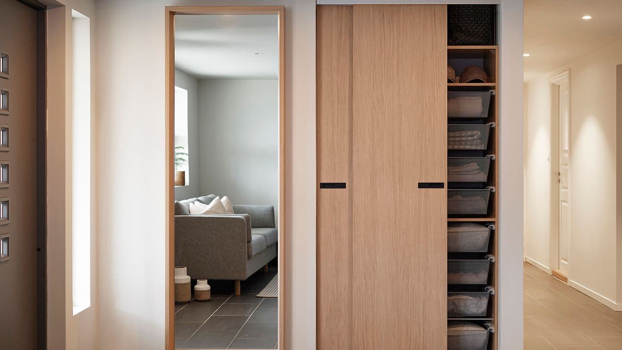 Garderobe i eik med skyvedørsfronter i entre.
