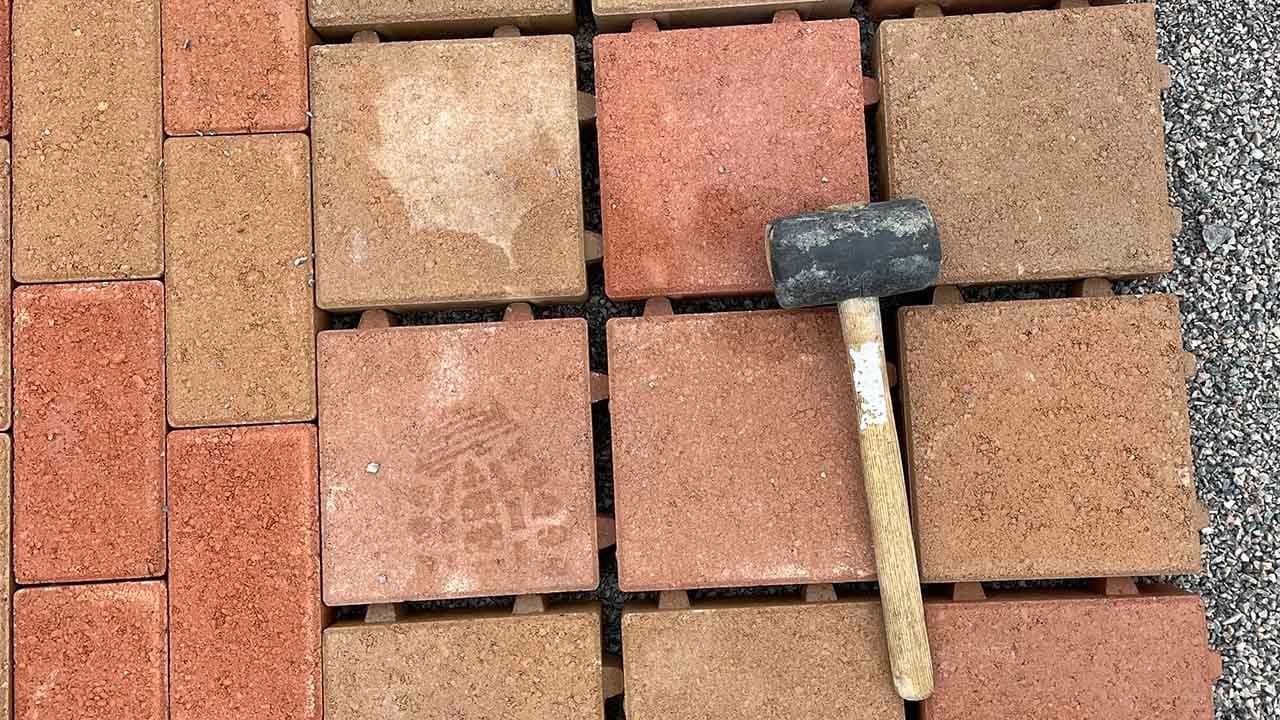 Nærbilde av gummihammer som ligger på permeabel belegningsstein som håndterer overvann på en smart og effektiv måte.