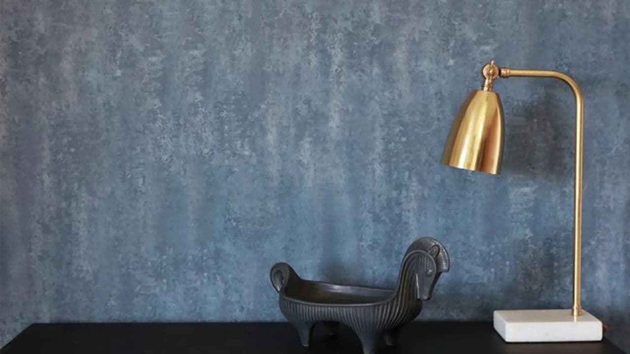 Blå veggplater og interiørdekor og messing bordlampe med marmorfot.