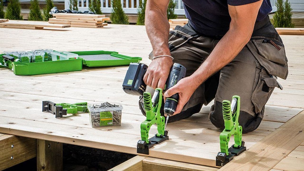 Person som holder på å bygge platting med HDs for skjult innfesting.