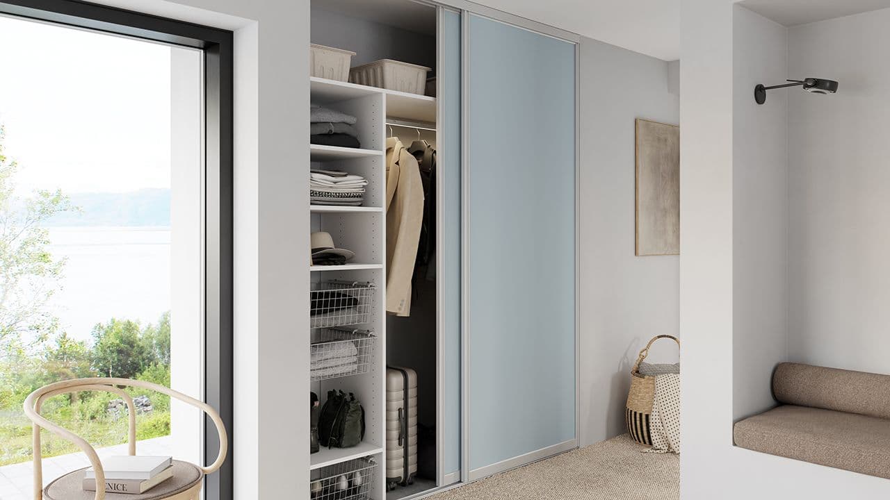 Lyseblå skyvedørsgarderobe i entré.