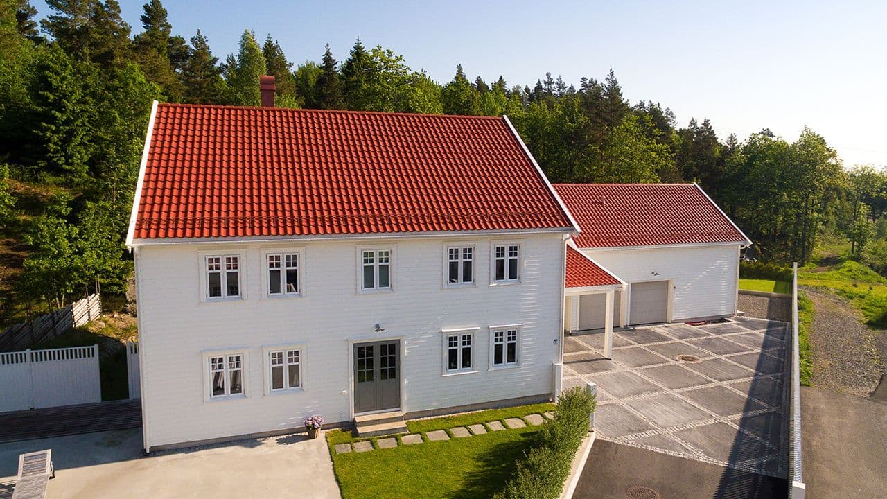 Hvit villa med rød takstein.
