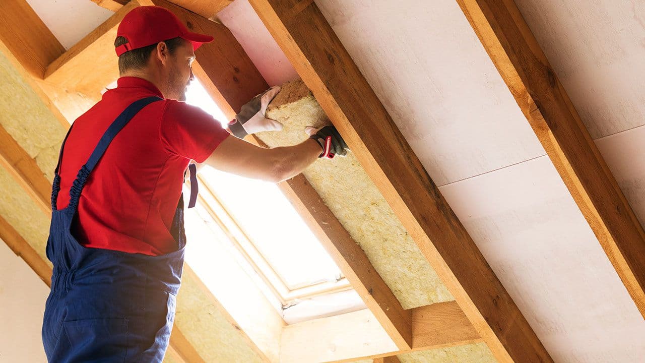 Person som etterisolerer et hus.