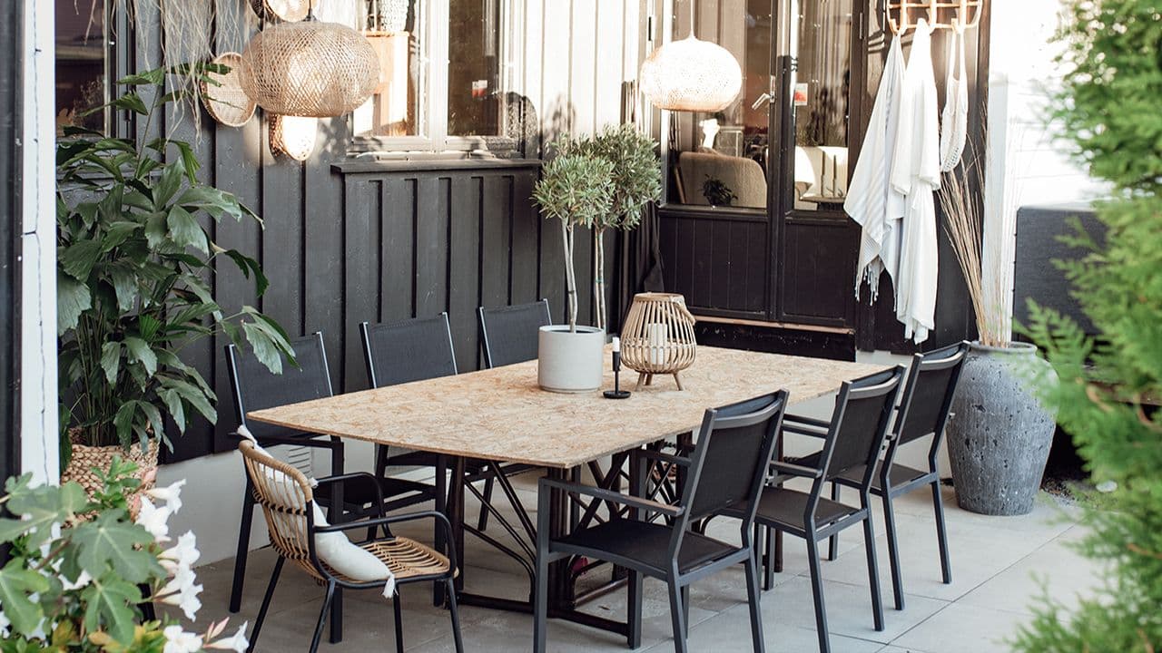 Uterom med spiseområdet i moderne sort og lyst treverk.