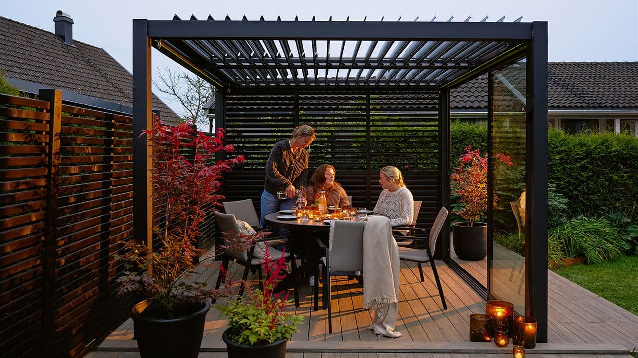 Venninner som spiser middag i utehage.