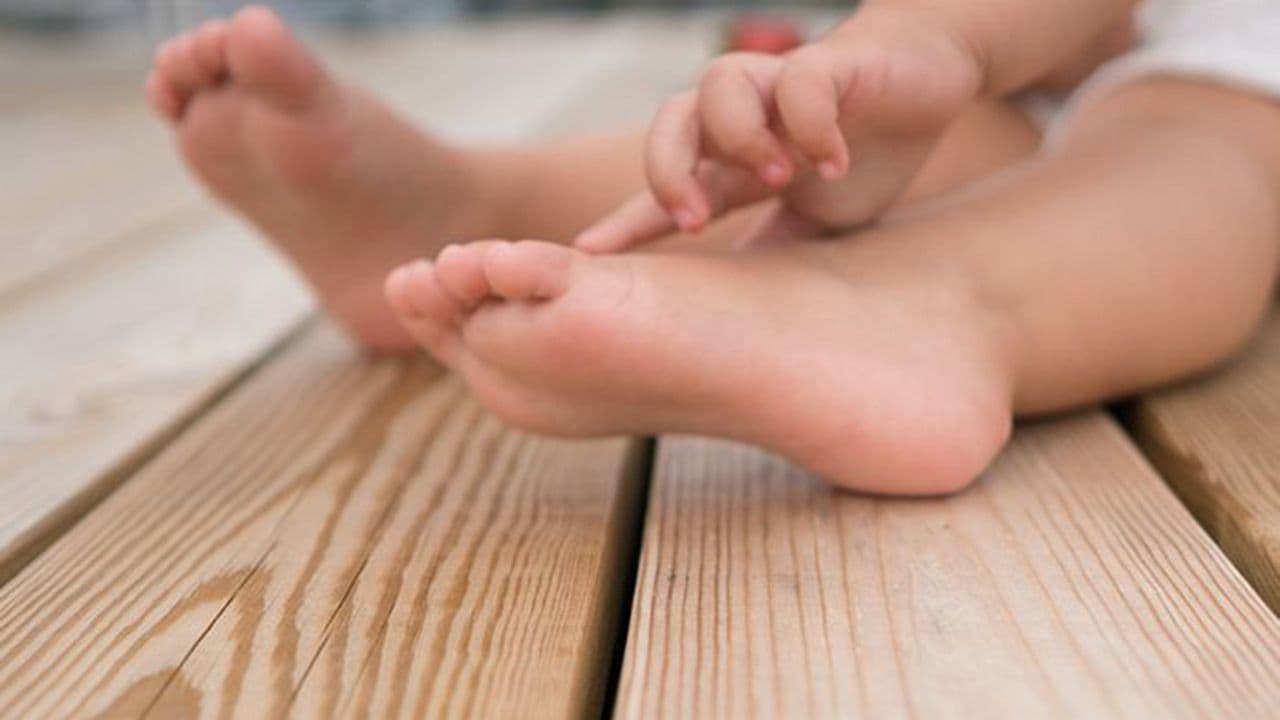 Barneføtter på trykkimpregnerte terrassebord.