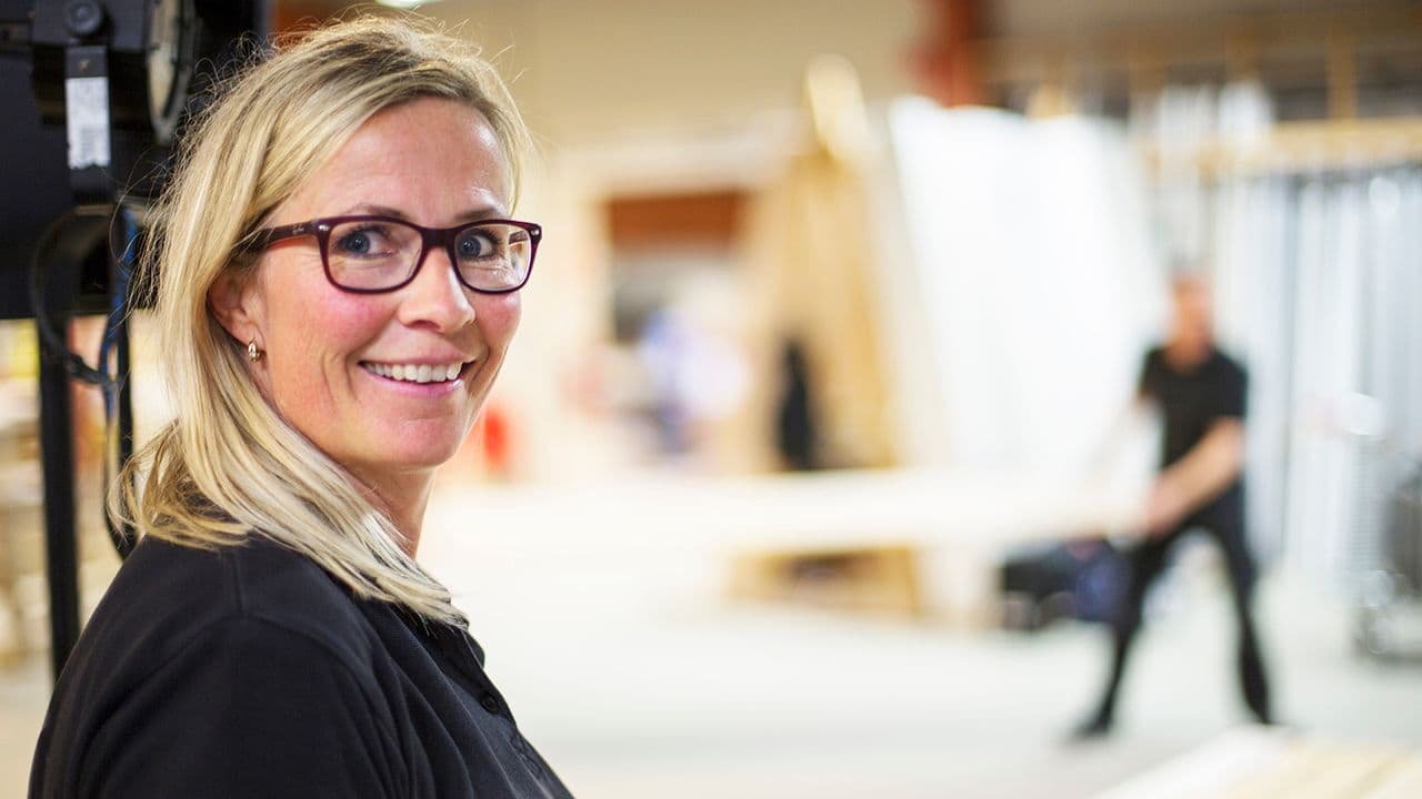 Kvinnelig ansatt hos XL-BYGG som smiler mot kamera.