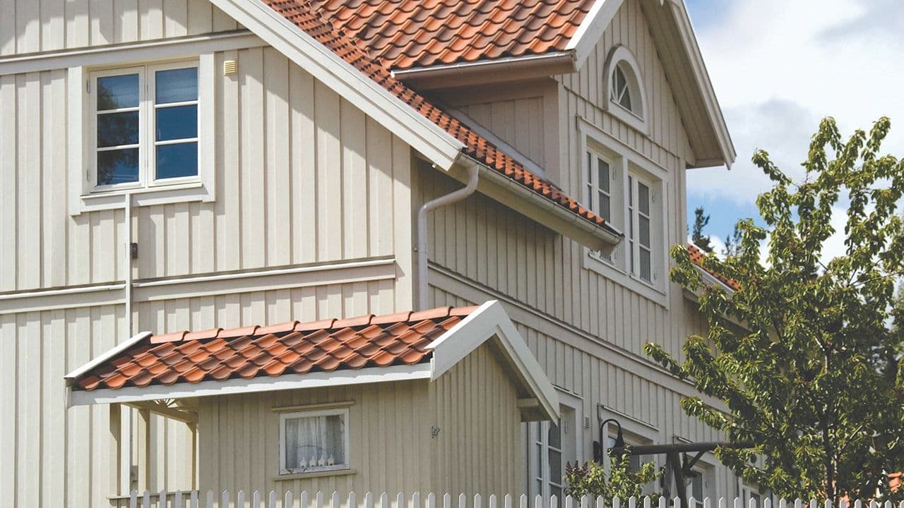 Beige hus med kledning i rektangulær profil.