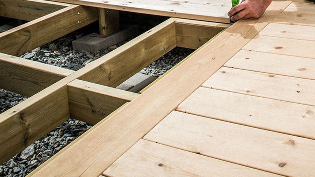 Nærbilde av platting og hånd til håndverker som holder på å bygge platting.