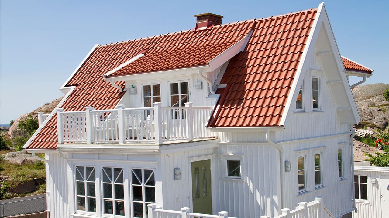 Hvit villa med rød takstein.