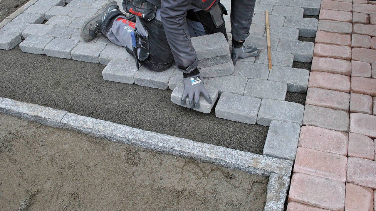 mann legger belegningsstein i halvforbandt mønster
