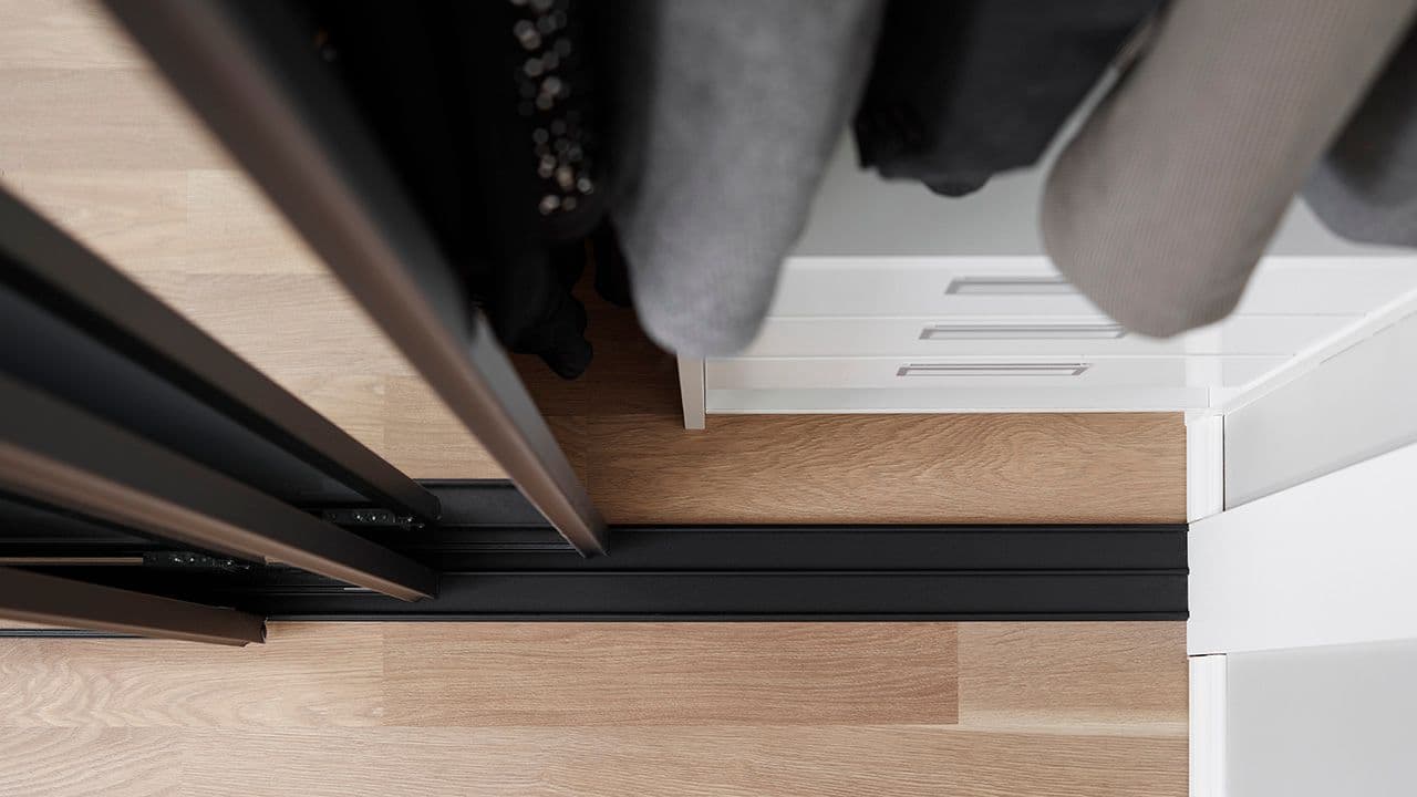 Garderobe med gulvskinner med opphøyde spor.