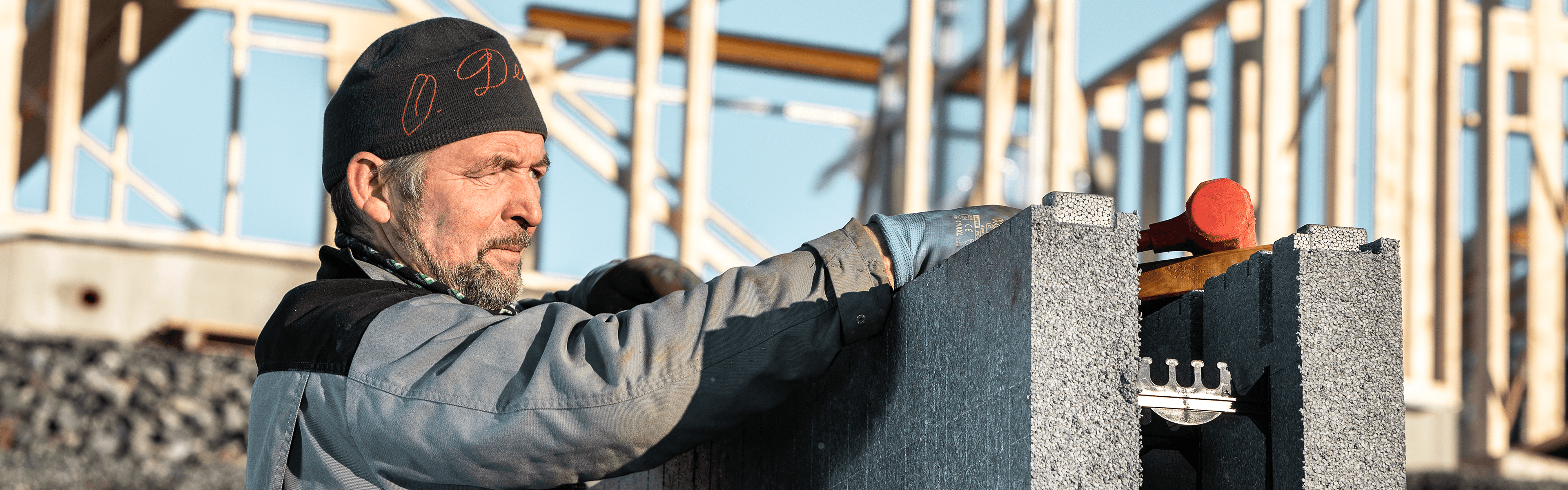 håndverker setter opp en ringmur på en byggeplass