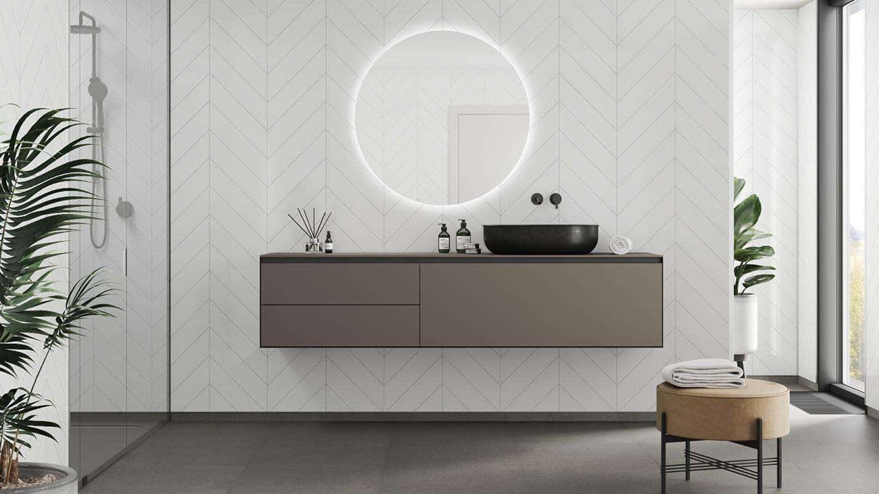 Baderom med hvite baderomsplater med chevron-mønster.