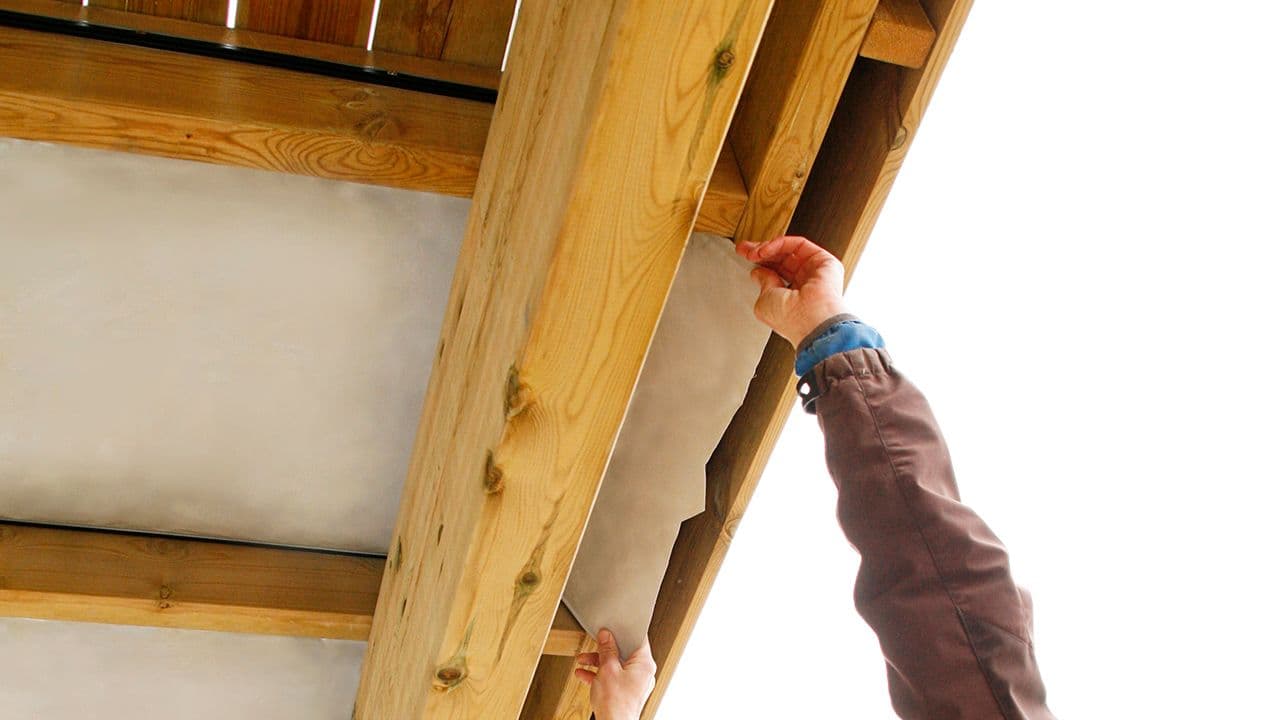 Person som ettermonterer for å få tett terrassegulv.