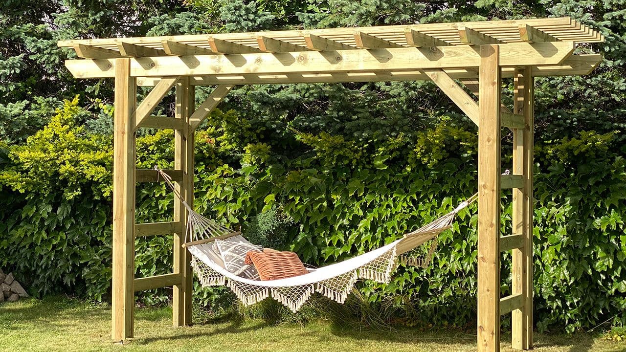 Liten pergola med hengekøye i hage.