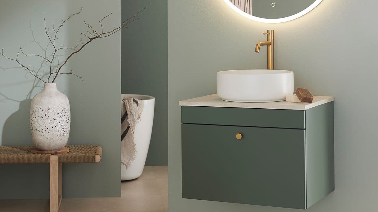 Grønt hyttebad med detaljer i messing.