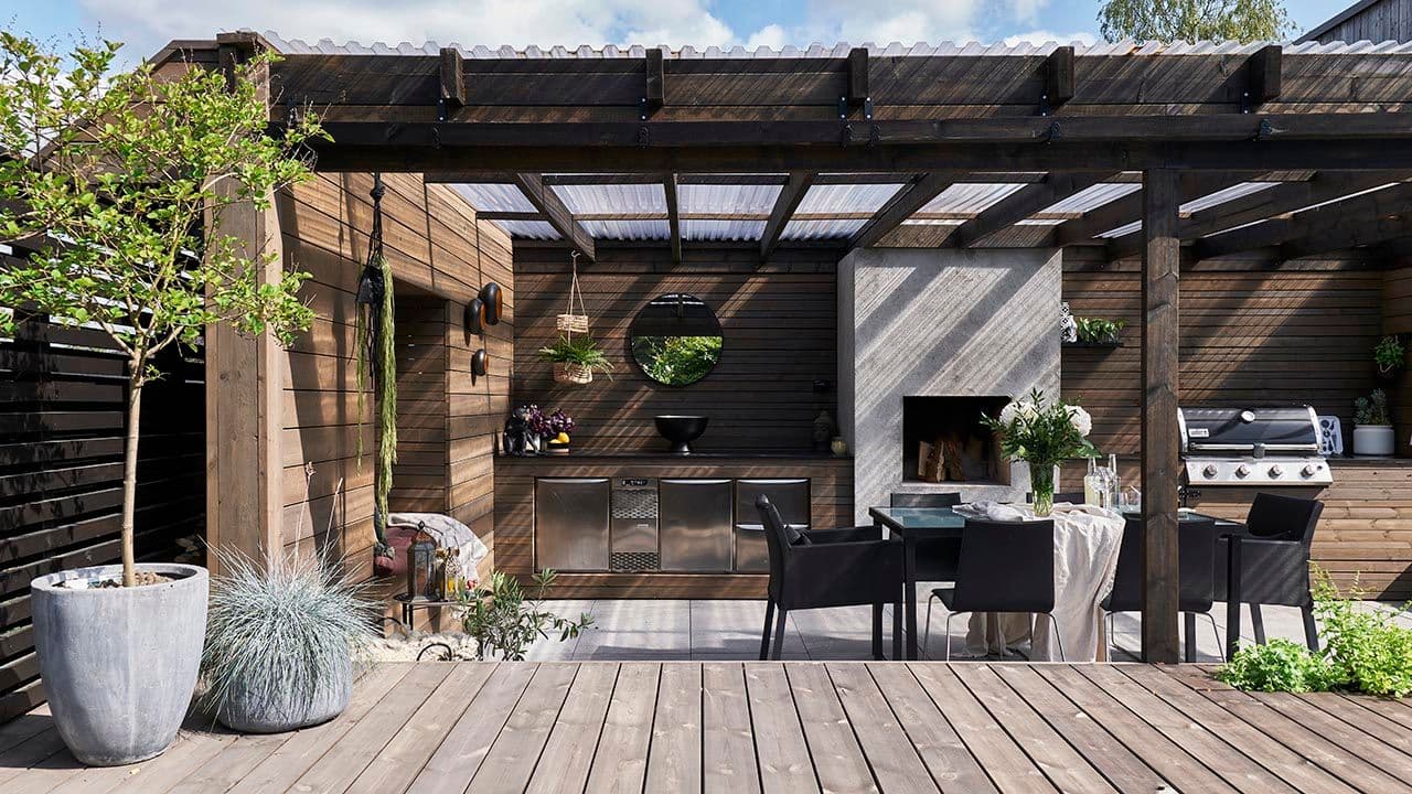 Terrasse med utekjøkken, spiseplass og tak.