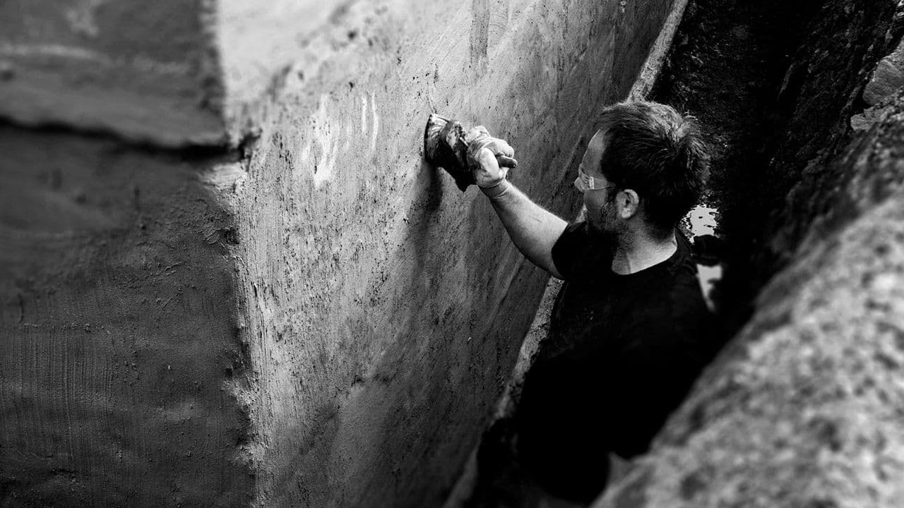 Håndverker som tetter mur.