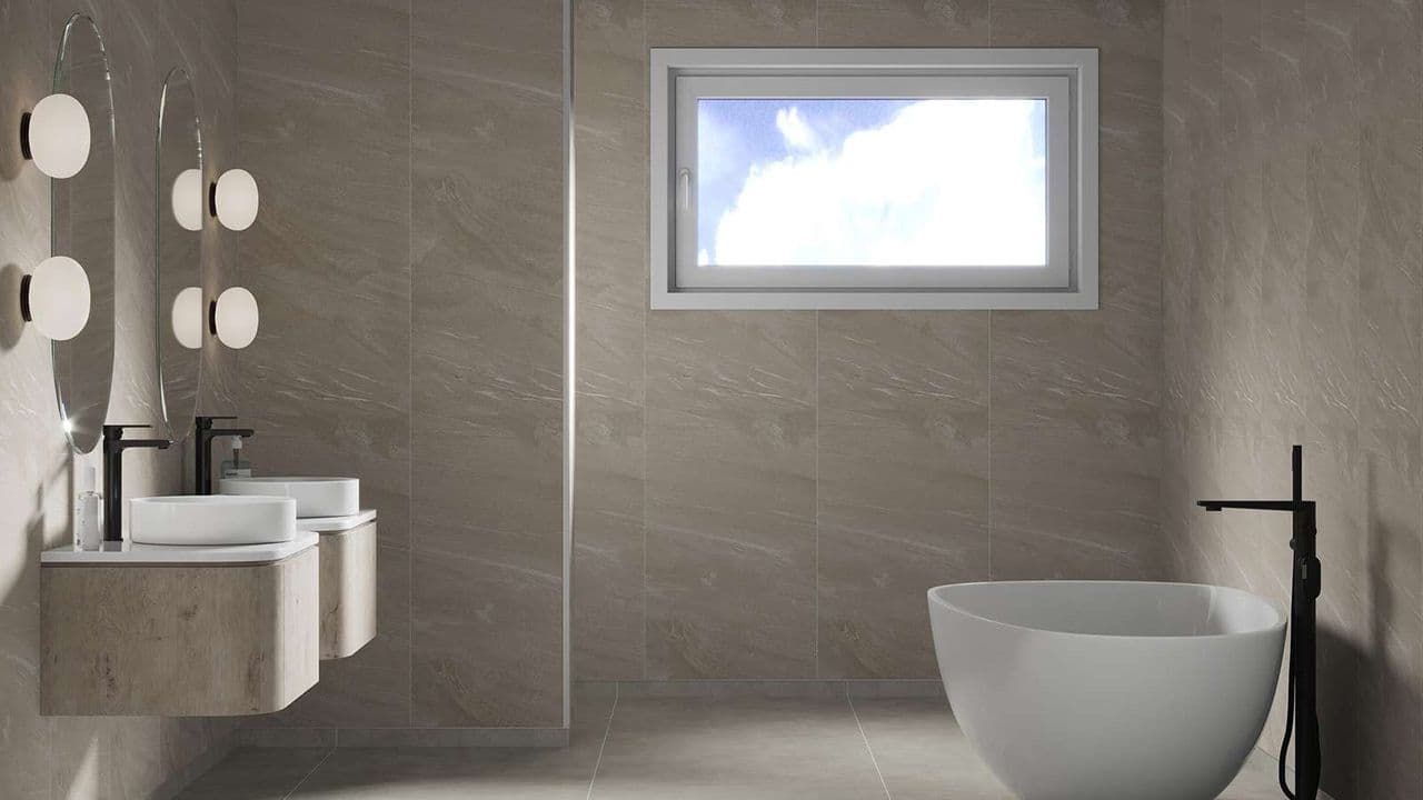 Beige Stone veggplate fra Fibo i stort bad med to servanter, dusjnisje og badekar.