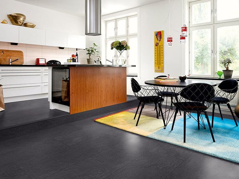 Kjøkken og spisestue med sort gulv.