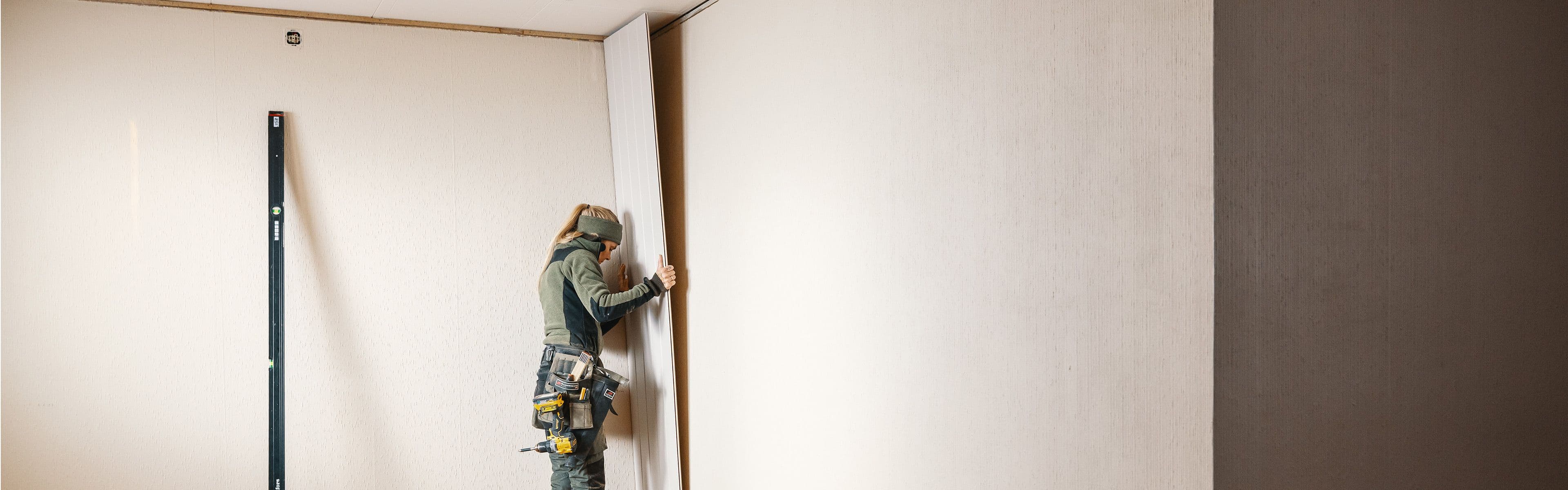 Dame som driver med montering av Huntonit veggplater.