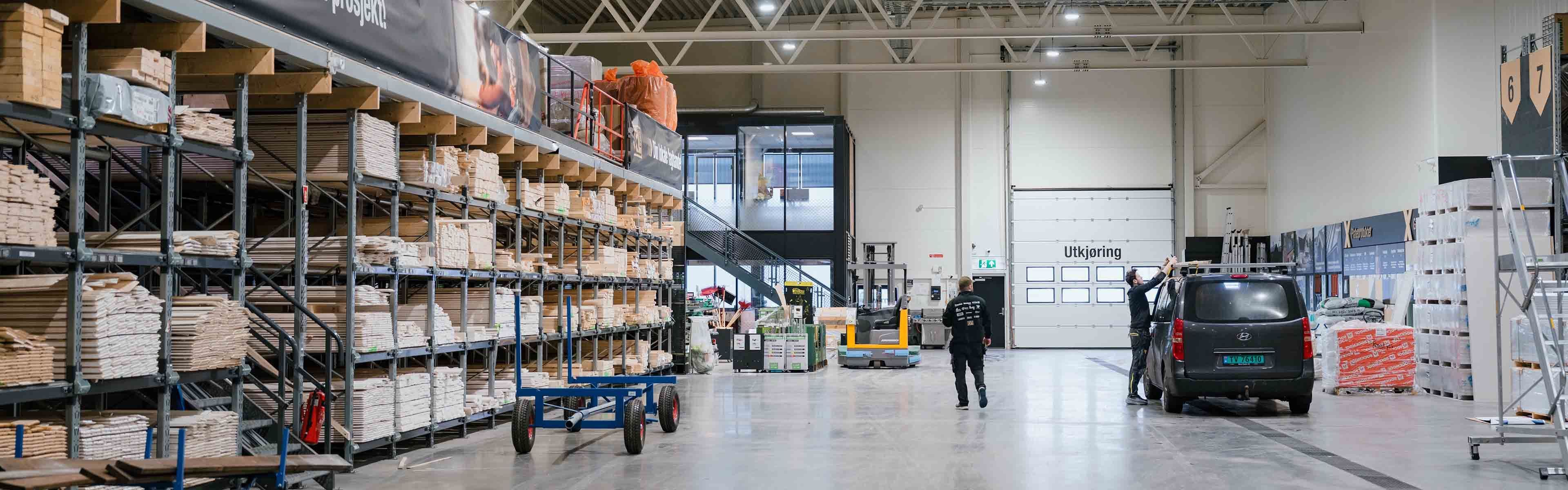 Lager med personer som lasser på en bil i XL-BYGG byggevarehus.