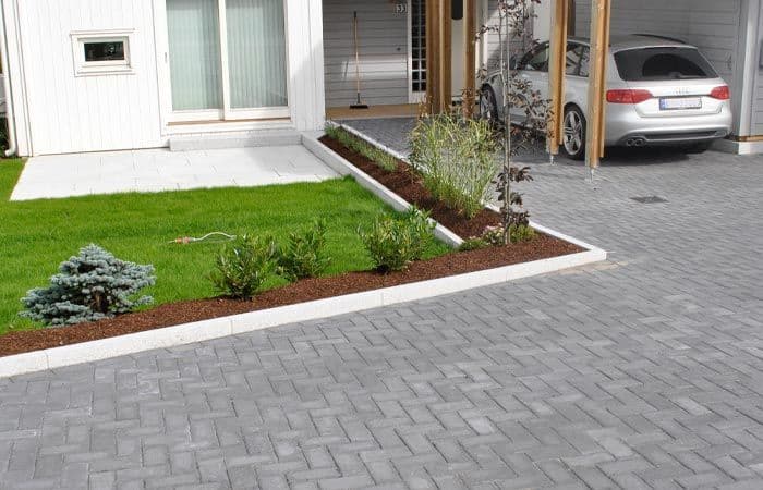 Bedkant laget med kantstein mellom plen og gårdsplass.