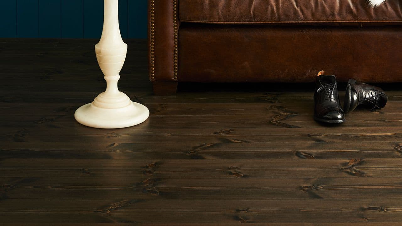 Nærbilde av mørkt furugulv i stue.
