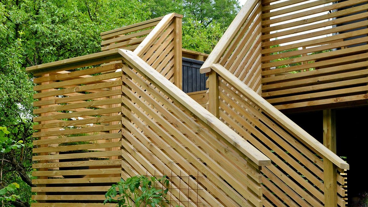 Terrasse med terrassetrapp i vinkel og spilerekkverk.