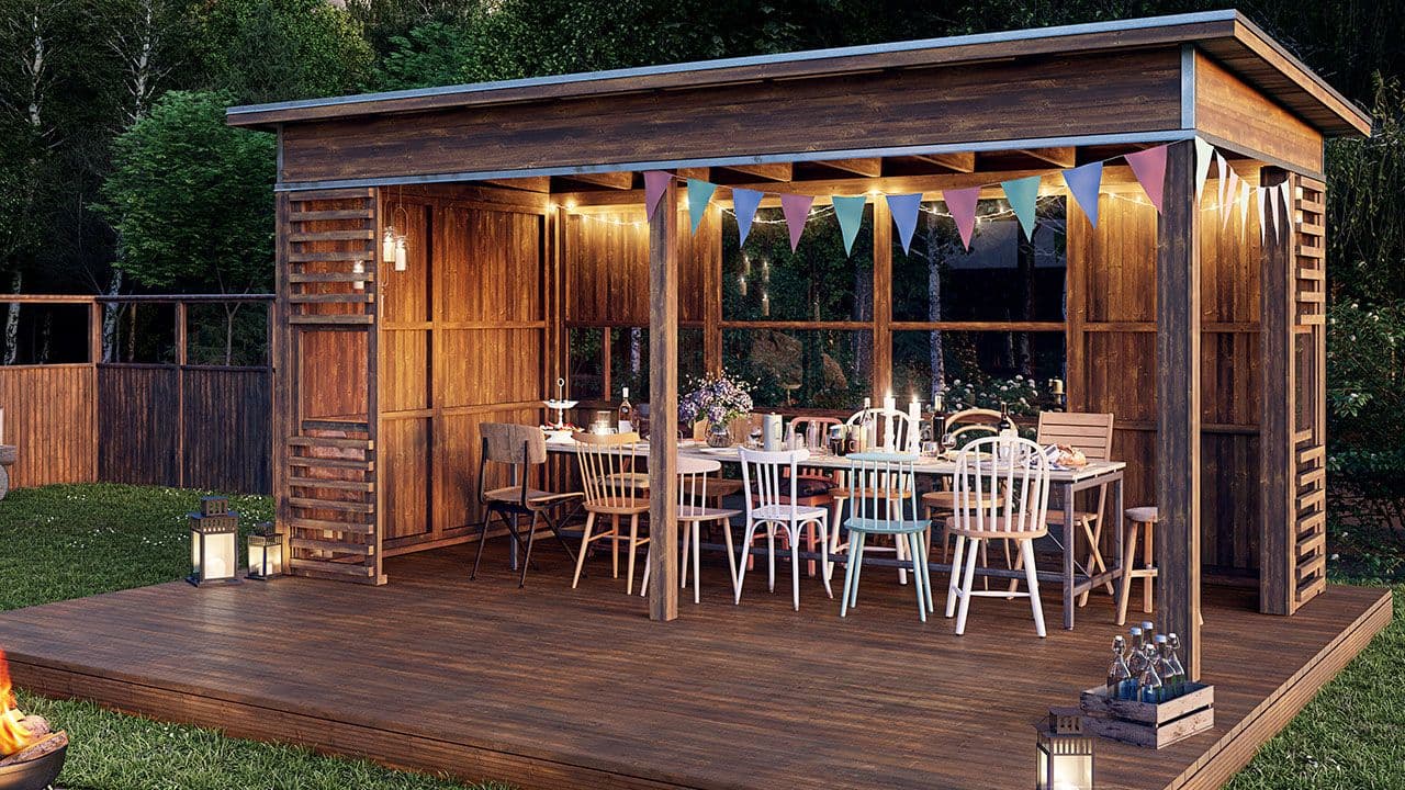 Hagestue på kvelden med stemningslys og stor spisegruppe.