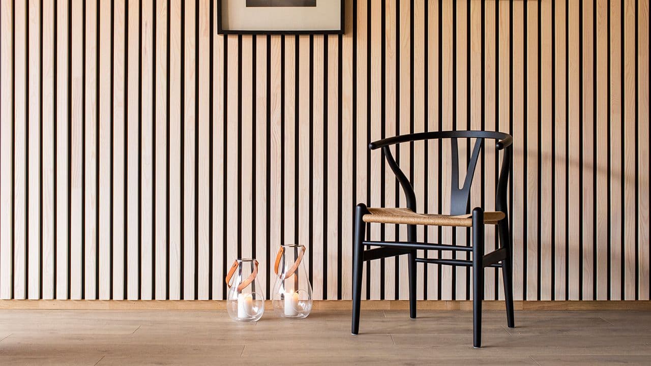 Vegg med spiler og sort Y-stol foran.